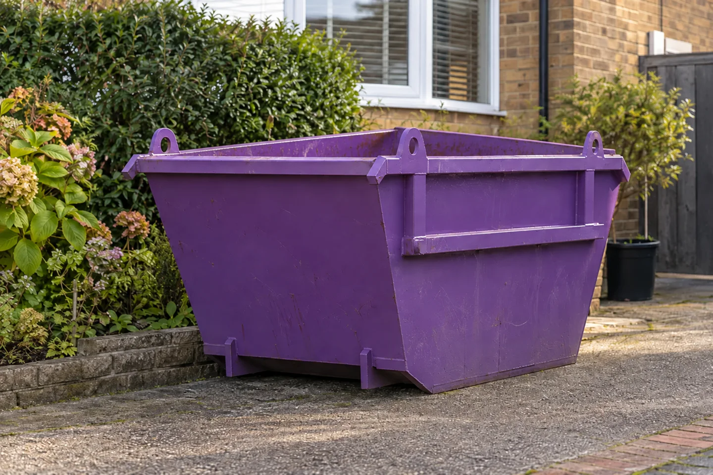 Skip positioned beside a property with space for loading